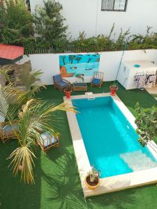 an empty swimming pool in a yard with chairs at Villa Sara DIALLO in Ngaparou