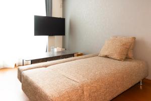 a living room with a couch and a flat screen tv at Kag R大濠1 in Fukuoka +27 photos