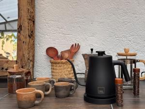 a tea kettle and cups on a table at Umbral Habitación Rústica con Desayuno Incluido in Tepoztlán