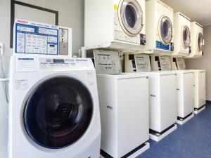 a laundry room with a washer and dryers on display at Hotel Meijiya in Hamamatsu