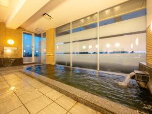 an indoor swimming pool with water in a building at Hotel Meijiya in Hamamatsu