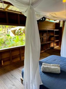 a bedroom with a bed with a canopy at Casa Caimito in Nuquí