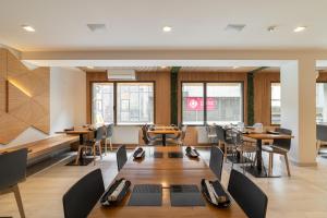 a restaurant with wooden tables and chairs and windows at LEE Hotel in Andorra la Vella