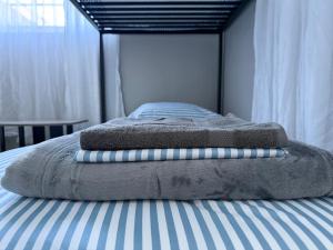 a bed with two towels on top of it at Bek's Hostel in Hallandale Beach +5 photos