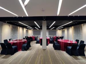 a conference room with red tables and black chairs at Midtown Xpress Balikpapan in Balikpapan
