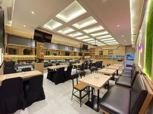 a restaurant with wooden tables and black chairs at Midtown Xpress Balikpapan in Balikpapan
