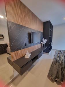 a living room with a tv on a wall at Studio Proximo Anashopping Kitnet 101 in Anápolis