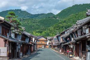 an empty street in an asian village with mountains at Kominka engawa in Kakamigahara