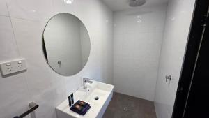 a white bathroom with a sink and a mirror at Longreach Most Central Motel in Longreach +41 photos