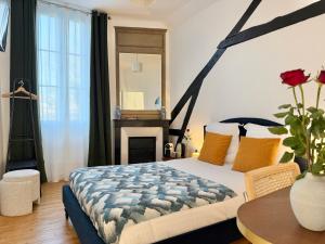a bedroom with a bed and a table and a mirror at Villa Ancestor - Etretat in Étretat