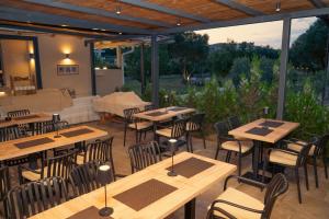 a restaurant with wooden tables and chairs on a patio at La Hacienda in Ulcinj