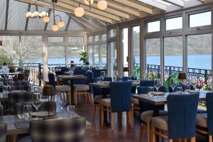 ein Restaurant mit Tischen, Stühlen und Fenstern in der Unterkunft Nomi Rooms & Restaurant in Bangor