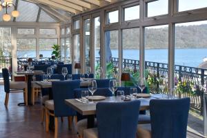 ein Restaurant mit Tischen, Stühlen und Fenstern in der Unterkunft Nomi Rooms & Restaurant in Bangor
