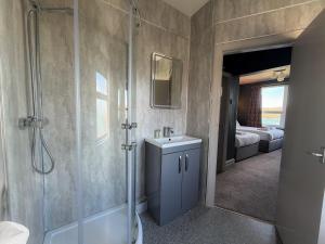 ein Badezimmer mit Dusche, Waschbecken und Spiegel in der Unterkunft Nomi Rooms & Restaurant in Bangor