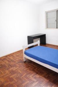 a bedroom with a bed and a desk in it at Quarto em Barretos, simples com paz e harmonia in Barretos