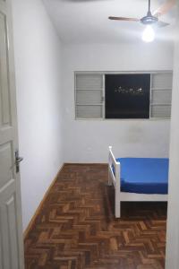 a room with a blue bed and a window at Quarto em Barretos, simples com paz e harmonia in Barretos +4 photos