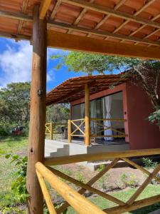 a small red house with a wooden fence at Chalé Lar do Capão in Vale do Capao