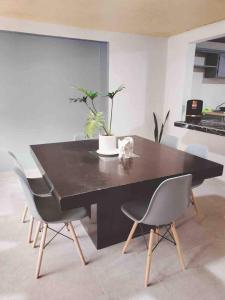 a dining room with a black table and chairs at Casa Altita Accommodation in Zacatlán +10 photos