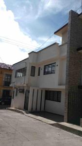 a white building with a garage in front of it at Casa Altita Accommodation in Zacatlán