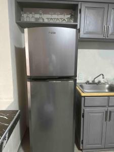 a stainless steel refrigerator in a kitchen with a sink at Casa Altita Accommodation in Zacatlán