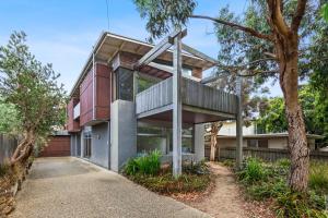 a house with a tree in front of it at Kingsley in Point Lonsdale
