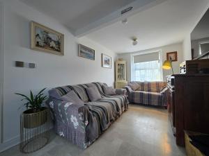 a living room with a couch and a tv at Butterlump Cottage in Glastry