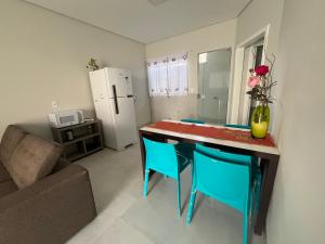 a kitchen with a table and chairs and a refrigerator at Residenc Mazonetto in Primavera do Leste