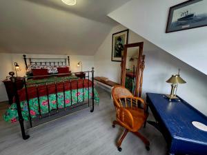 a bedroom with a bed and a desk and a chair at Butterlump Cottage in Glastry
