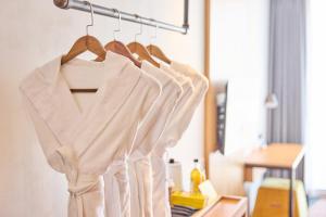 a group of white shirts hanging on a rack at L7 HONGDAE by LOTTE HOTELS in Seoul