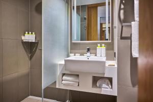 a bathroom with a white sink and a mirror at L7 HONGDAE by LOTTE HOTELS in Seoul