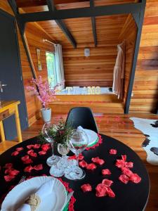 a table with wine glasses and red rose petals on it at Chalé das Laranjeiras in Planalto