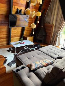 a living room with two couches and a table at Chalé das Laranjeiras in Planalto