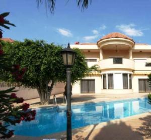 een huis met een lichtpaal voor een zwembad bij Patatas Villa in Limassol