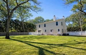 a white house with a fence and a yard at Charming Home for a Perfect Escape in East Hampton