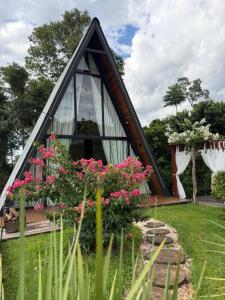 a frame house with flowers in the yard at Chalé das Laranjeiras in Planalto