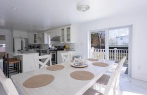 a kitchen and dining room with a white table and chairs at Charming Home for a Perfect Escape in East Hampton