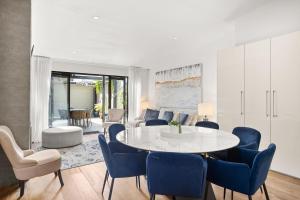 a dining room with a white table and blue chairs at Albertine House in Melbourne