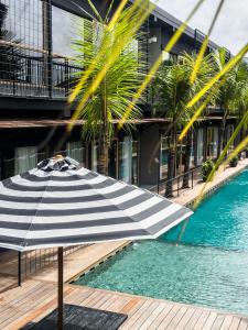a black and white umbrella sitting next to a swimming pool at Koji Collection in Kerobokan