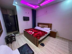 a bedroom with a bed and a purple light at Palace inn Hotel in Dargai
