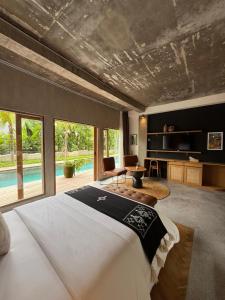 a bedroom with a bed and a living room at Koji Collection in Kerobokan