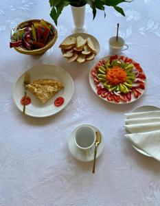a table with plates of food and a bowl of food at Hôtel Foham Oasis in Bandjoun