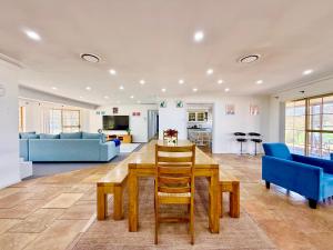 a living room with a table and blue chairs at Marrangaroo Meadows in Marrangaroo