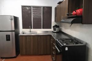a kitchen with a stainless steel refrigerator and a sink at Edificio AREAS by QuBeLab in Bello