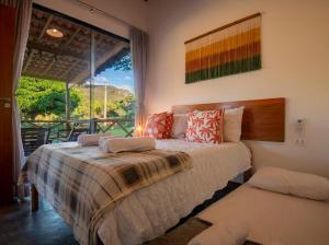 a bedroom with a bed and a large window at Chalé Lar do Capão in Vale do Capao
