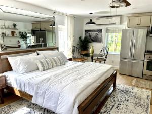 a bedroom with a large white bed and a kitchen at Buttonwood Hotel 1 - Boutique Accommodations in Cape May +100 photos