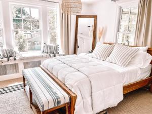 a large white bed in a room with windows at Buttonwood Hotel 1 - Boutique Accommodations in Cape May