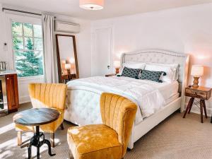 a bedroom with a large white bed and a chair at Buttonwood Hotel 1 - Boutique Accommodations in Cape May