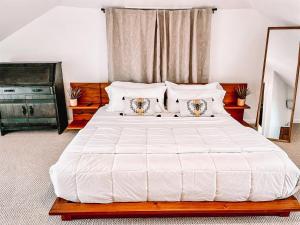 a bedroom with a large white bed with pillows at Buttonwood Hotel 1 - Boutique Accommodations in Cape May