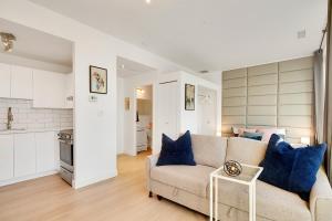 a living room with a couch and a kitchen at City Centre Studio - Best Location! in Vancouver