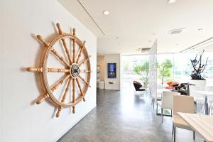 a large wooden wheel on the wall in a dining room at Hotel nanvan浜名湖 in Kosai